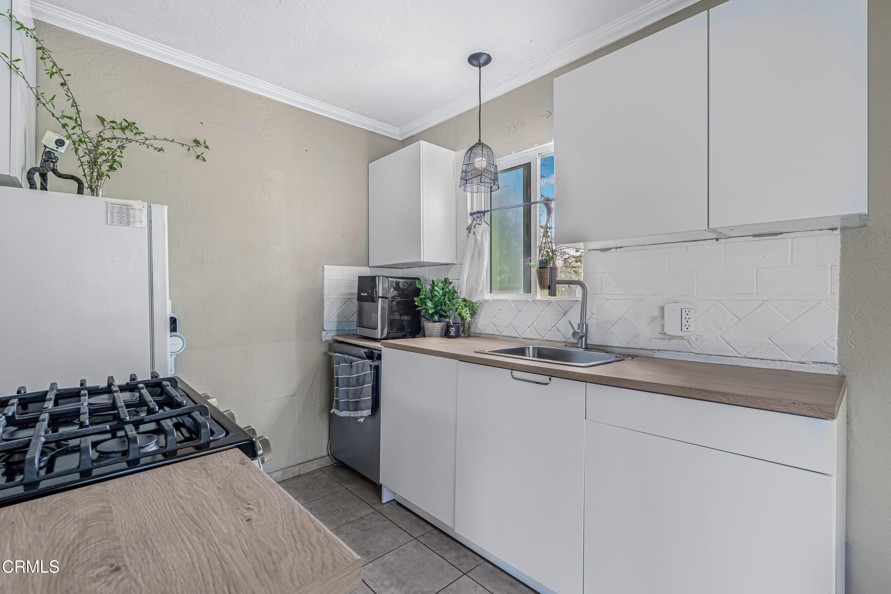6045 Oak Knolls Road Simi Valley, CA 93063 - Photo 10 of 25 a kitchen with stainless steel appliances a sink and a refrigerator