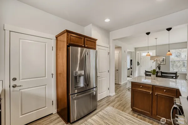 a kitchen with stainless steel appliances granite countertop a refrigerator a sink and white cabinets