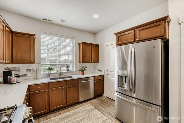 a kitchen with stainless steel appliances a refrigerator sink and cabinets