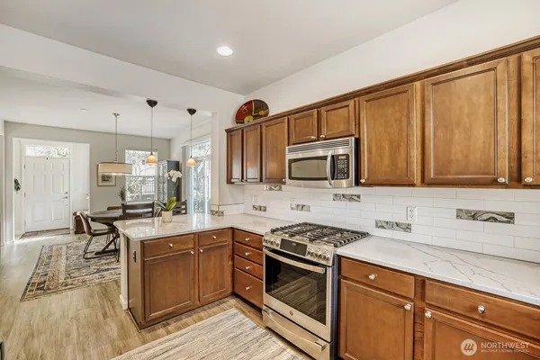 a kitchen with stainless steel appliances granite countertop a sink stove and cabinets