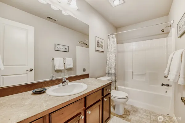 a bathroom with a granite countertop sink toilet and shower