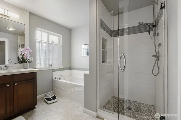 a bathroom with a granite countertop sink a mirror a bathtub and shower