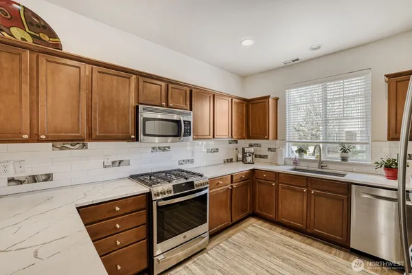 a kitchen with stainless steel appliances stove microwave sink and cabinets