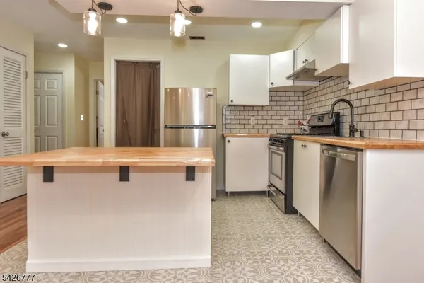 a kitchen with stainless steel appliances granite countertop a sink a stove and a refrigerator