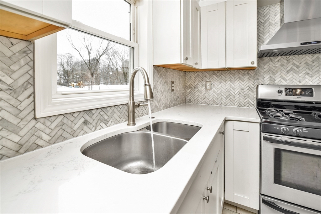 153 Colburn Street Dedham, MA 02026 - Photo 12 of 40 a kitchen with a sink and a stove next to a window