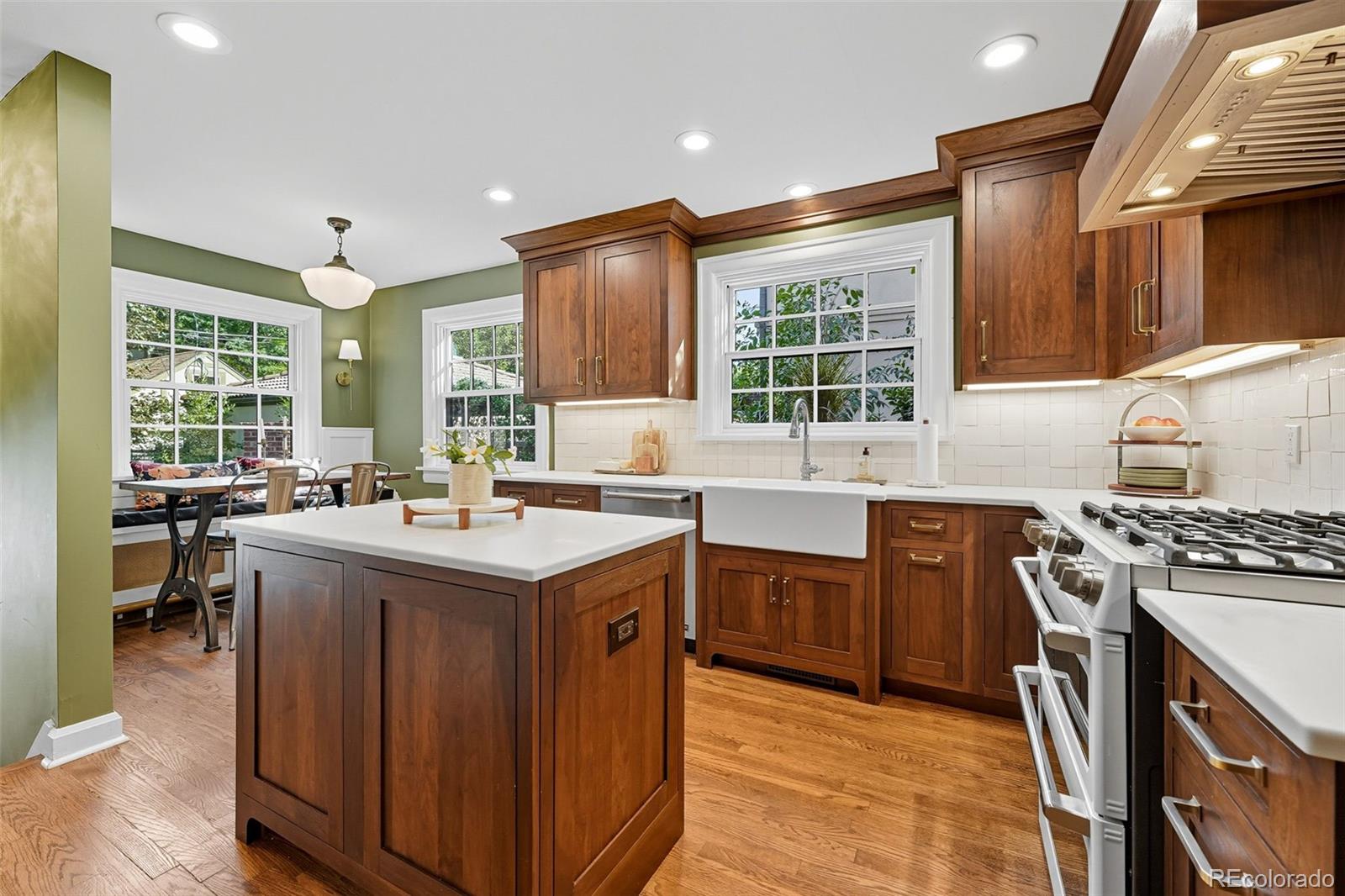 1750 Jasmine Street Denver, CO 80220 - Photo 10 of 35 a kitchen with a stove a sink a kitchen island with a dining table and chairs