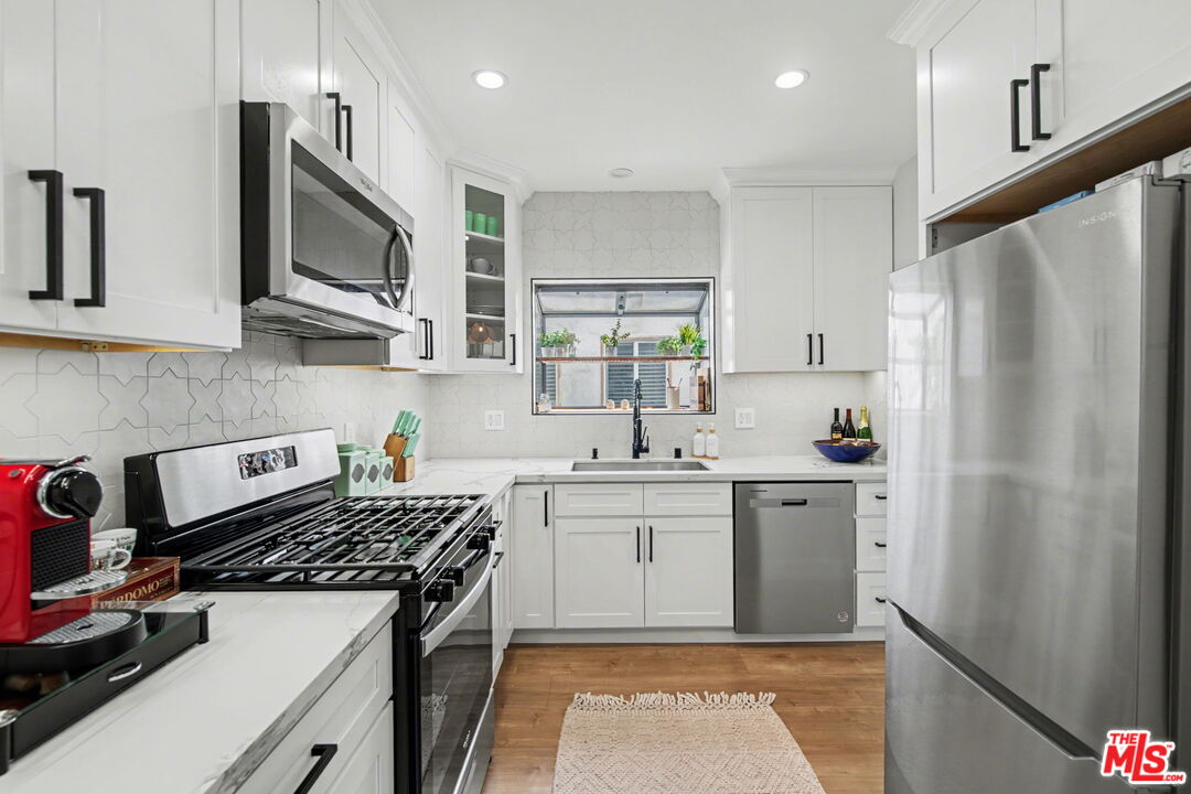 1135 West 81st Place Los Angeles, CA 90044 - Photo 11 of 28 a kitchen with stainless steel appliances a sink stove and refrigerator