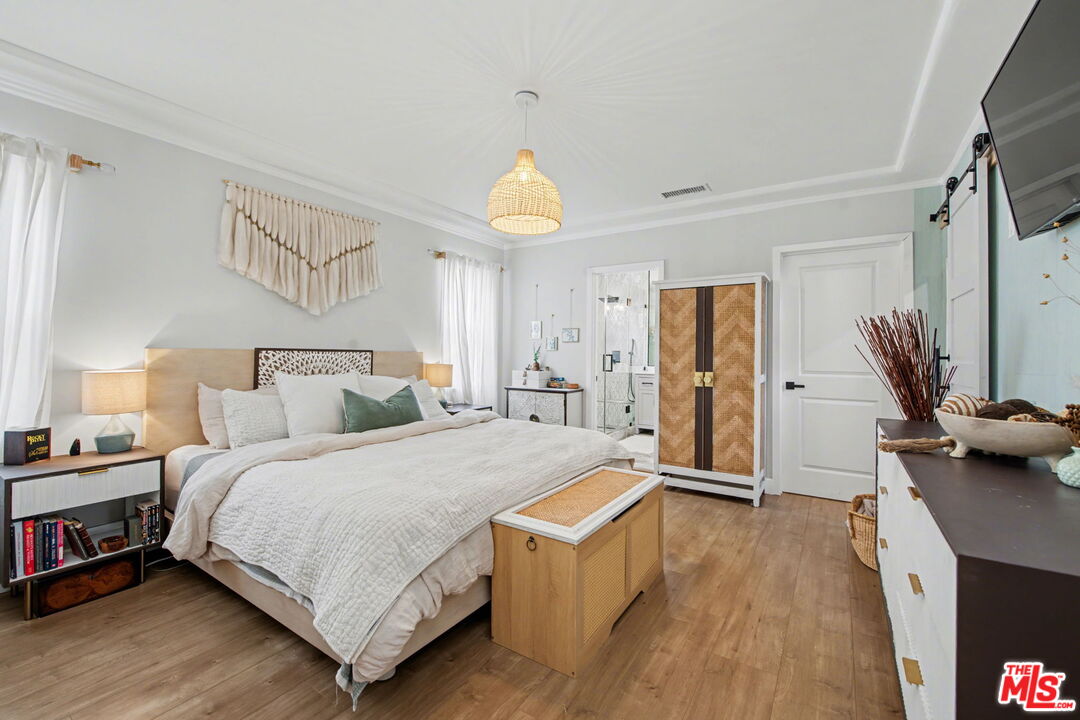 1135 West 81st Place Los Angeles, CA 90044 - Photo 17 of 28 a spacious bedroom with a bed and a chandelier