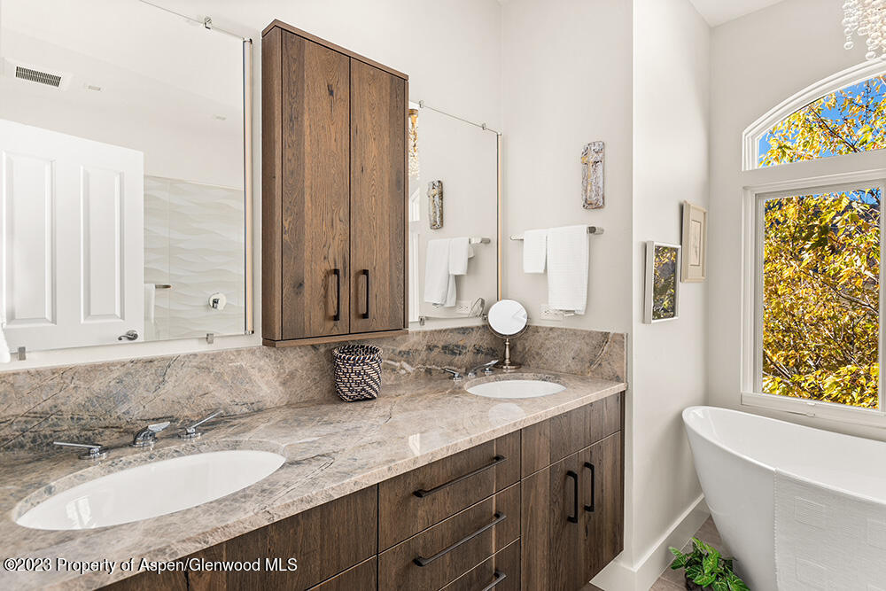 587 Hillcrest Drive Basalt, CO 81621 - Photo 11 of 29 a bathroom with a granite countertop double vanity sink a mirror and a bathtub