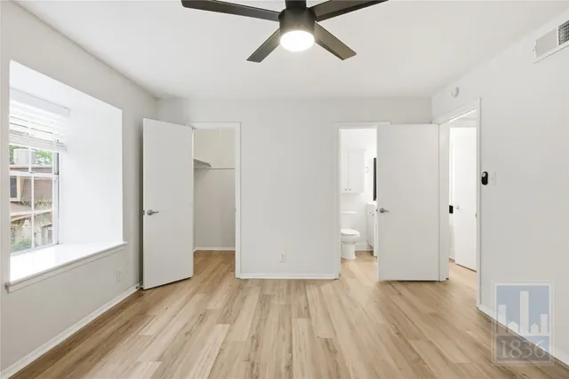 a view of empty room with wooden floor and window