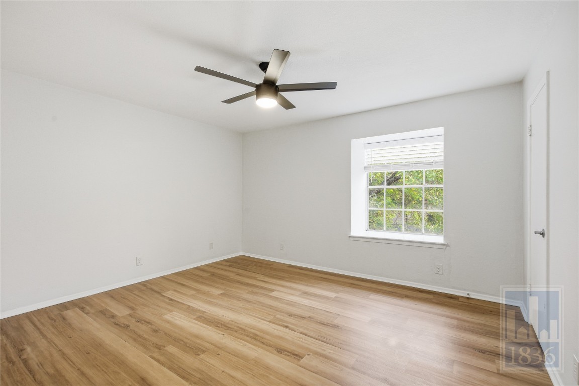 7801 Shoal Creek Boulevard, Unit 256 Austin, TX 78757 - Photo 13 of 27 wooden floor in an empty room with a window