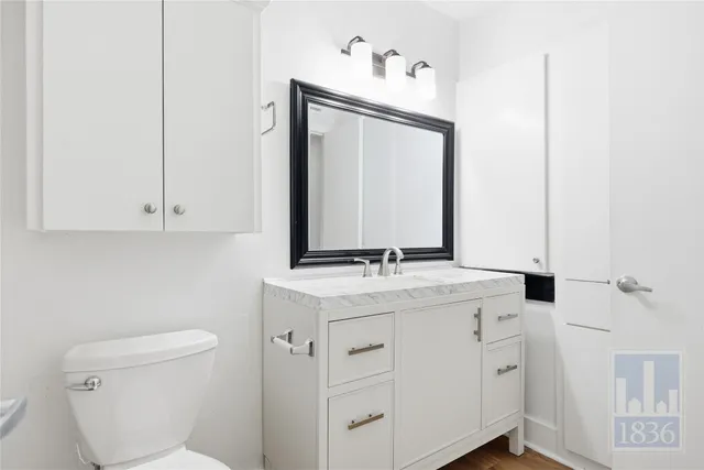 a bathroom with a toilet sink and mirror