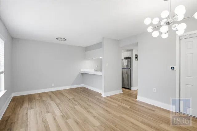 a view of a room with wooden floor and a window