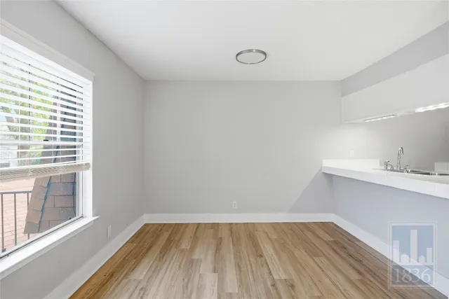 a view of a kitchen with wooden floor and a sink