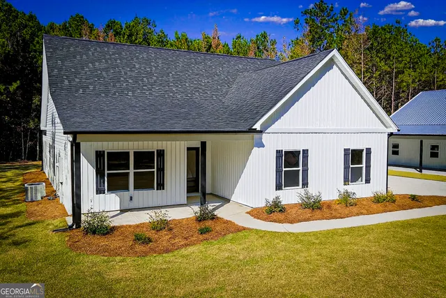 a view of a house with backyard and sitting area