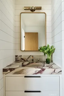 a bathroom with a granite countertop sink a toilet and shower