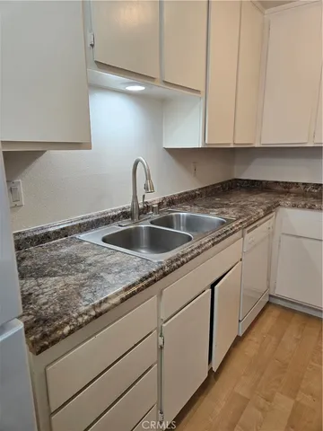 a kitchen with granite countertop a sink and cabinets