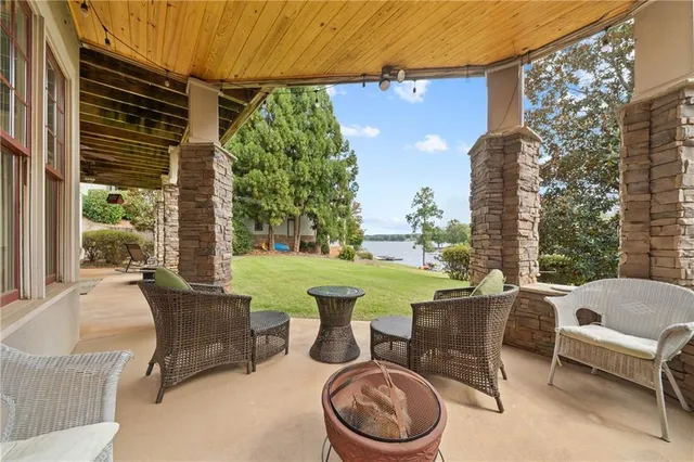 a kitchen with granite countertop a refrigerator a sink and white cabinets