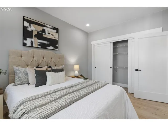 a bedroom with a bed and a painting on the wall