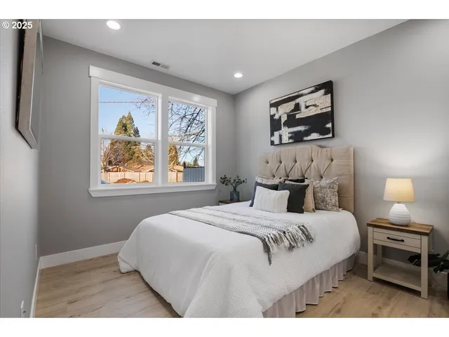 a bedroom with a bed and a painting on the wall