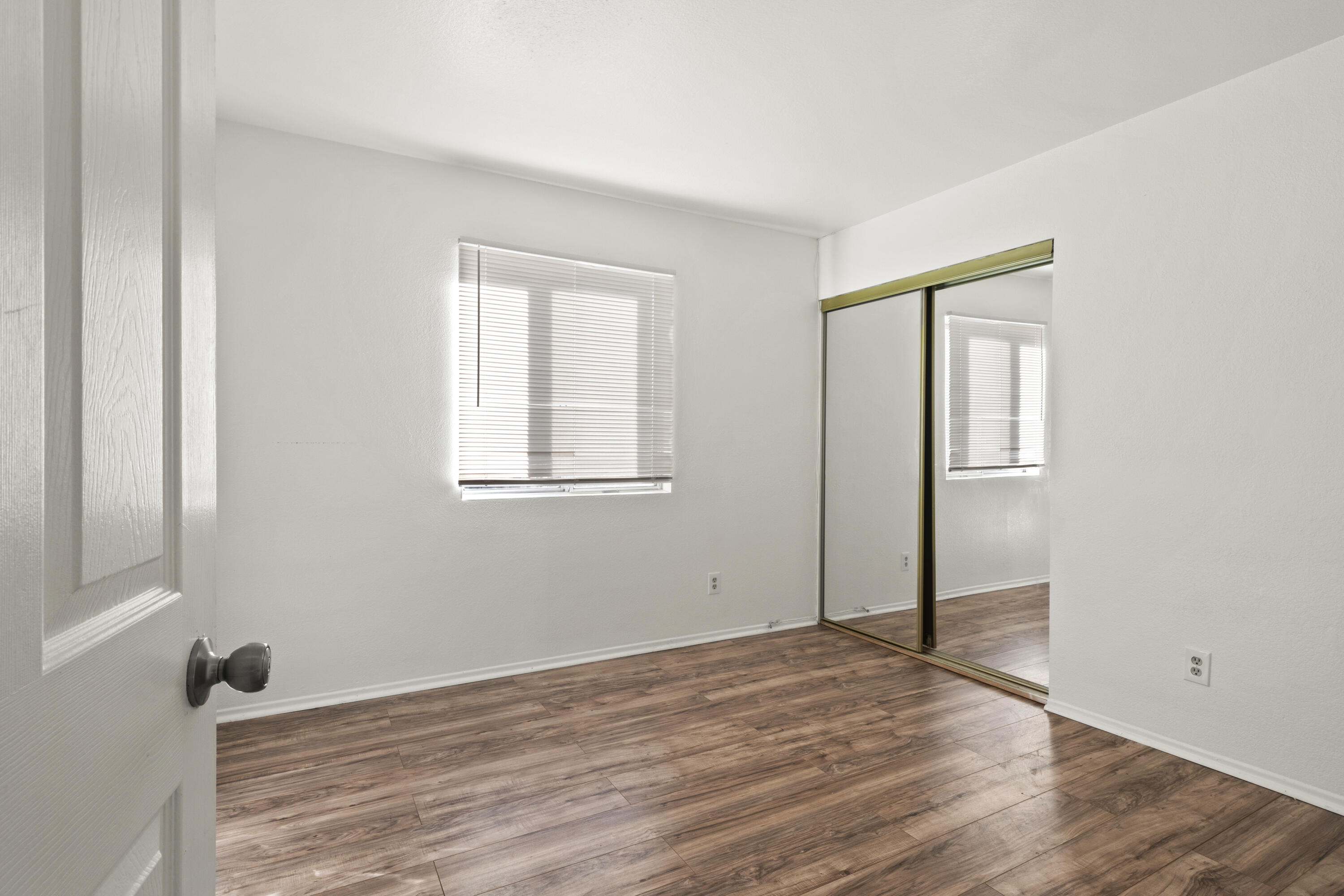1551 Coventry Place Palmdale, CA 93551 - Photo 5 of 12 an empty room with wooden floor and windows