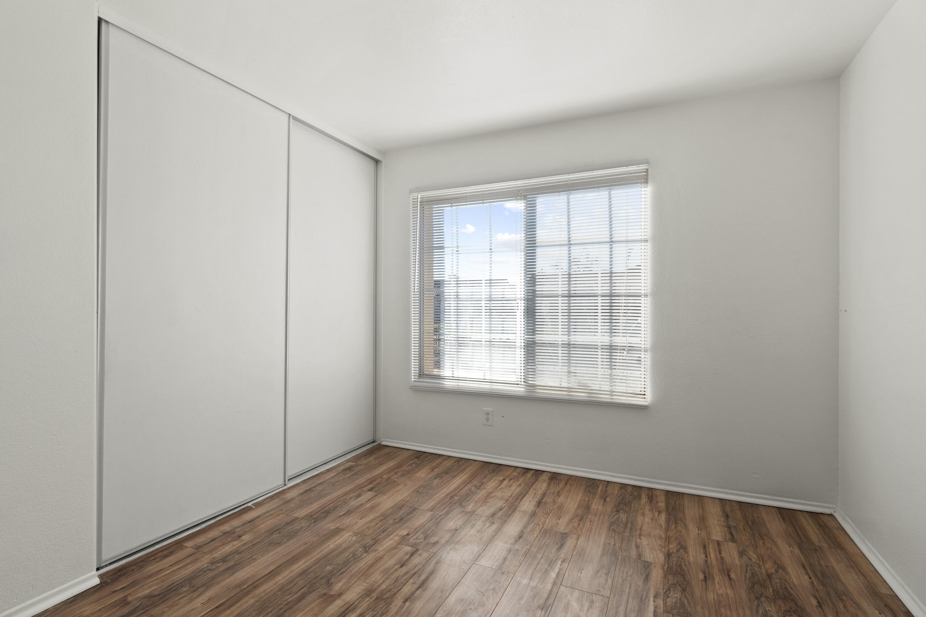 1551 Coventry Place Palmdale, CA 93551 - Photo 7 of 12 an empty room with wooden floor and windows
