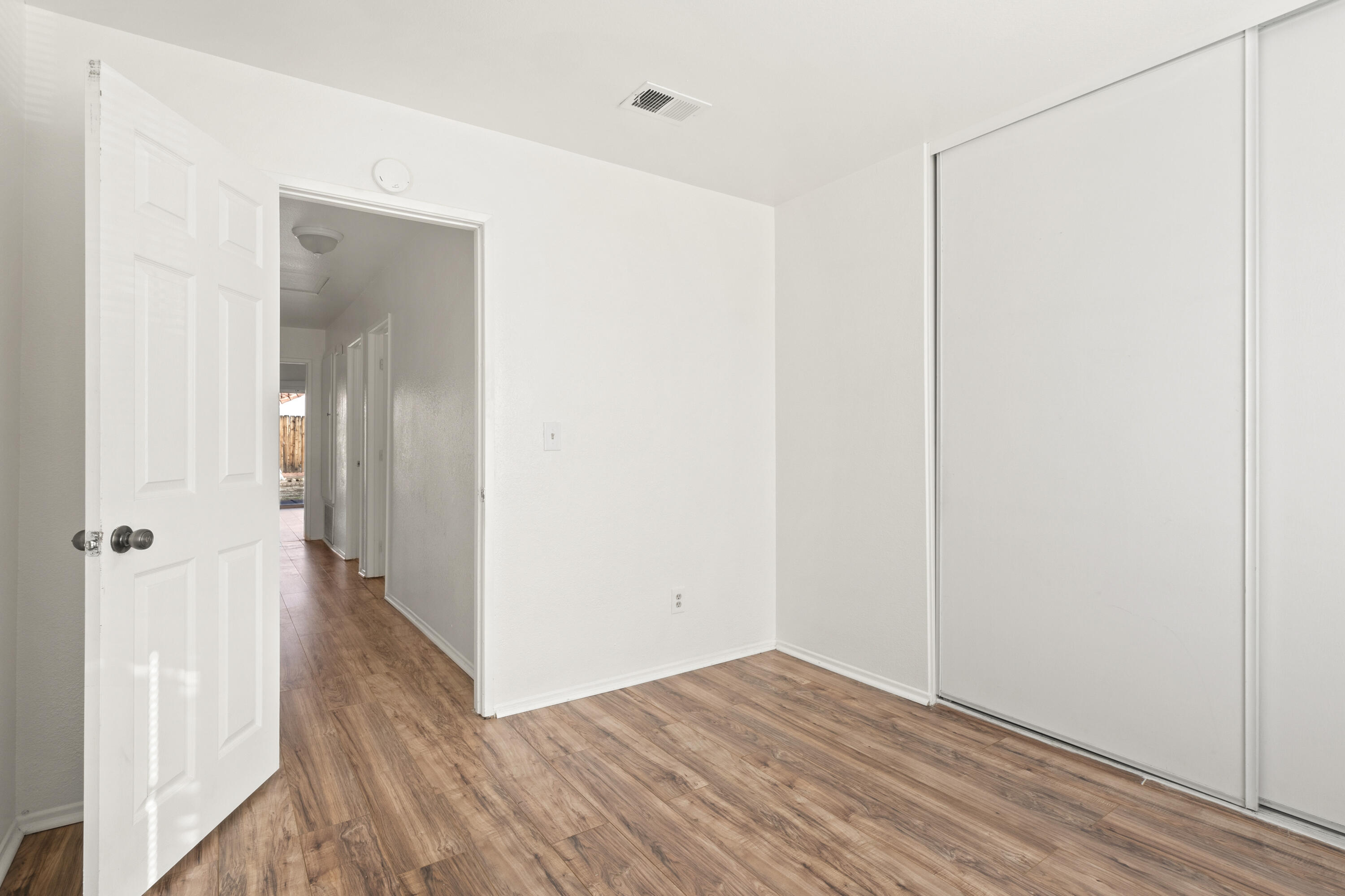 1551 Coventry Place Palmdale, CA 93551 - Photo 8 of 12 a view of a hallway with wooden floor