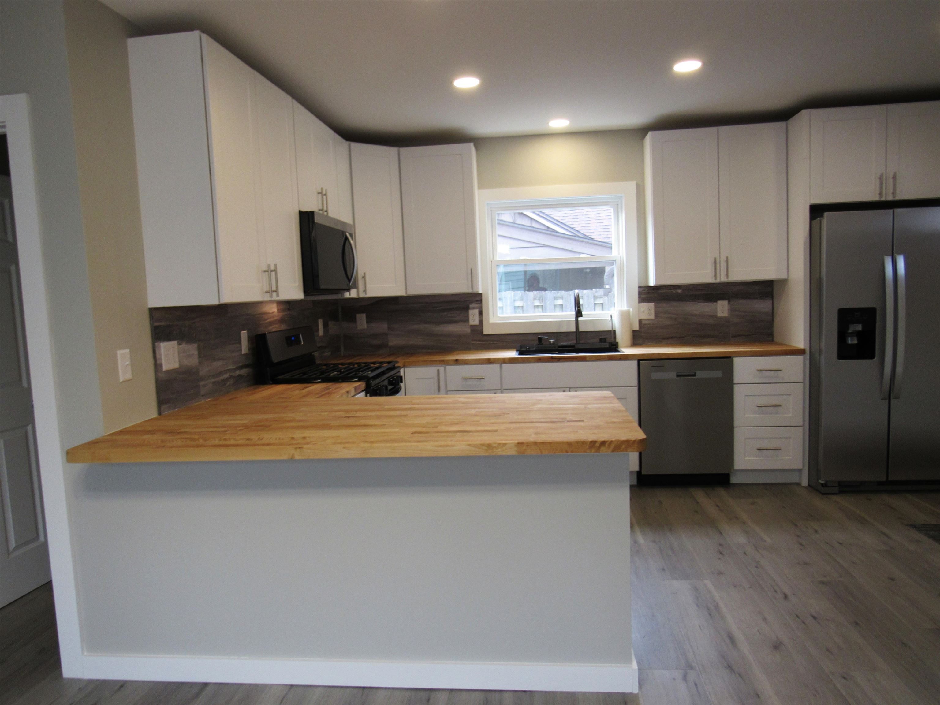 336 Belteberg Road Loves Park, IL 61111 - Photo 6 of 23 a kitchen with stainless steel appliances granite countertop a sink a stove a refrigerator cabinets and wooden floor