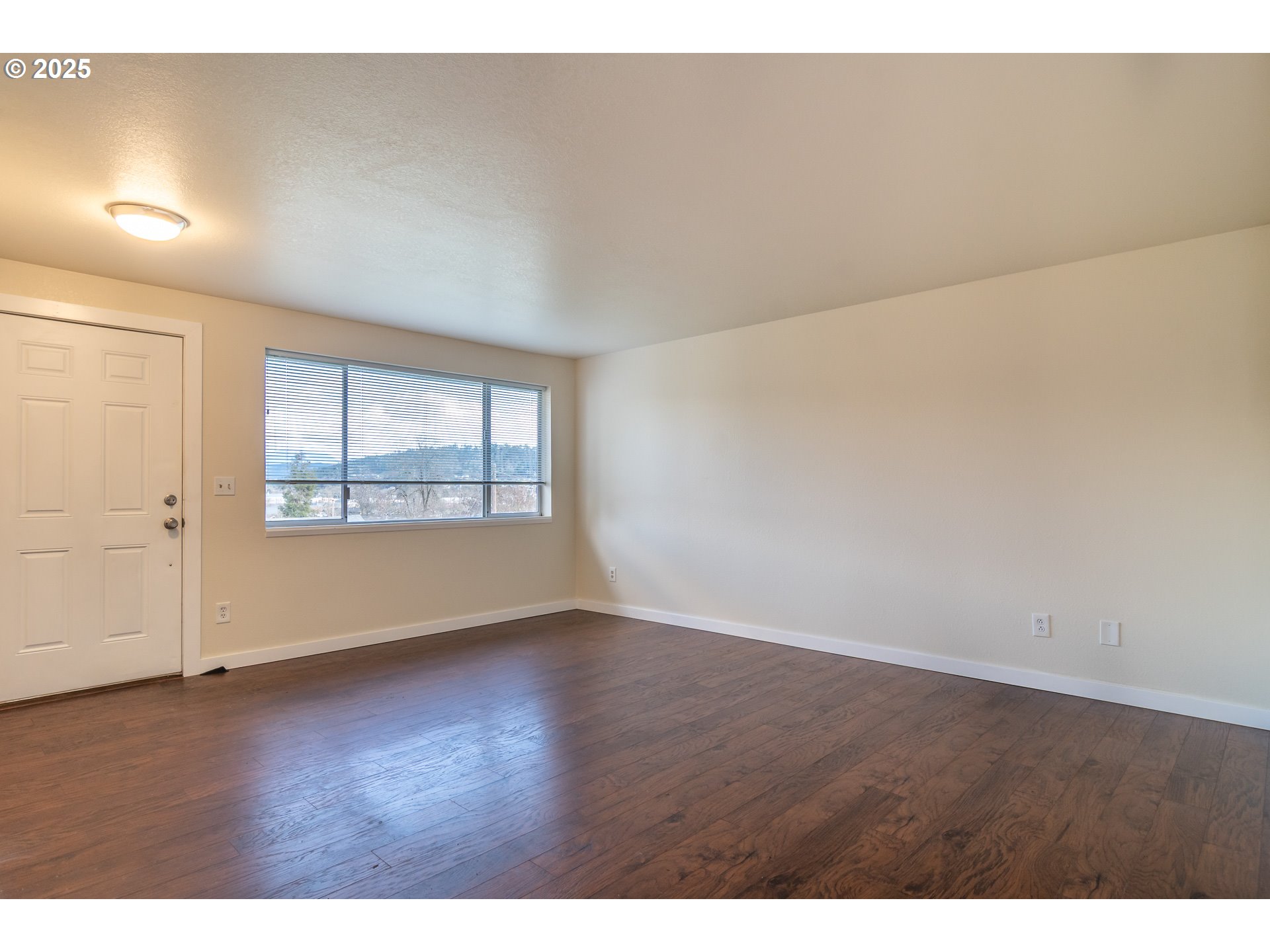 341 Ash Street Sutherlin, OR 97479 - Photo 3 of 28 an empty room with wooden floor and windows