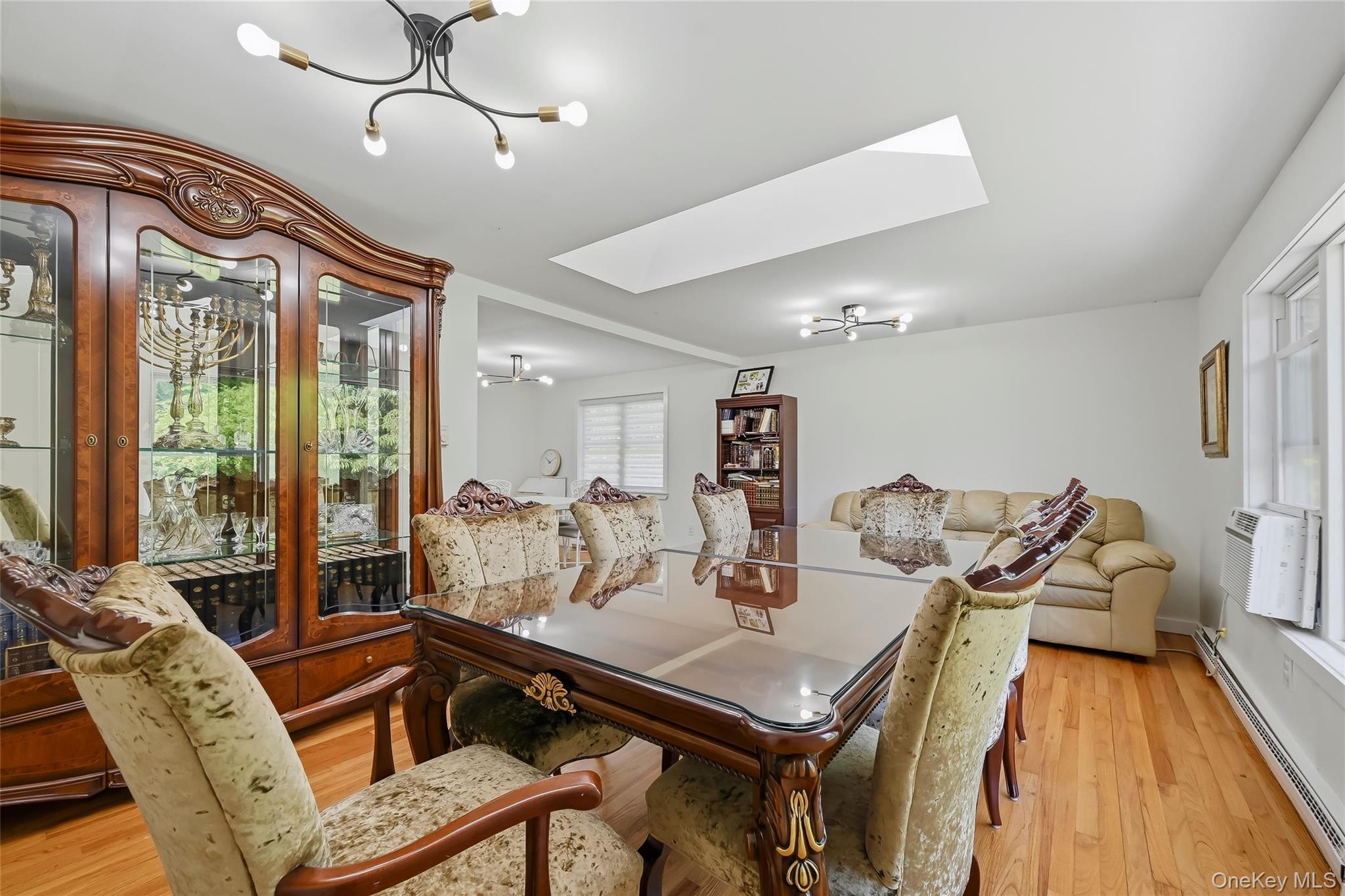 249 Ridge Road Highland Mills, NY 10930 - Photo 12 of 38 Hardwood flooring throughout a bright room featuring a ceiling-mounted light fixture and a skylight