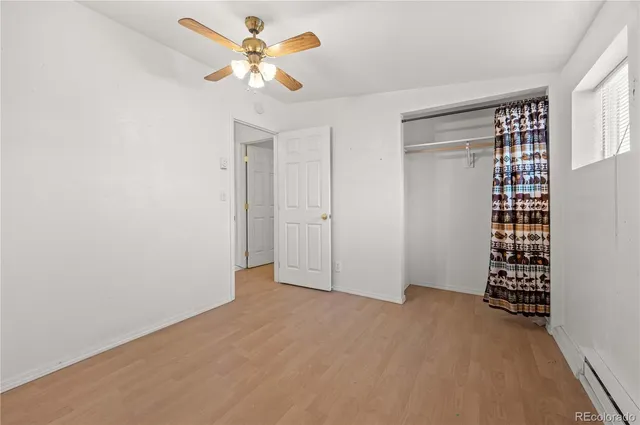 an empty room with a window and a ceiling fan