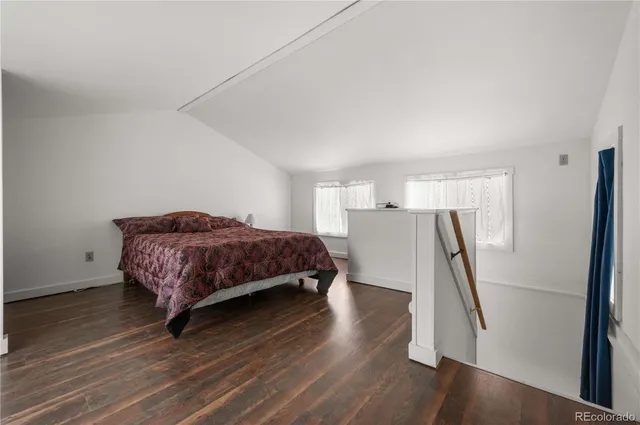 a bedroom with a bed and a wooden floor