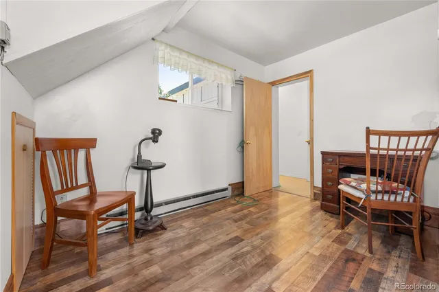 a view of room with wooden floor and chairs