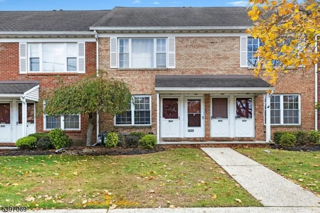 front view of a brick house with a yard