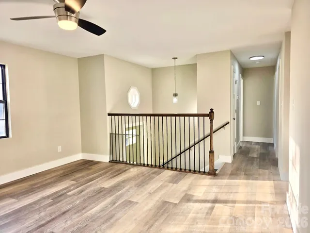 a view of a room with a ceiling fan and window