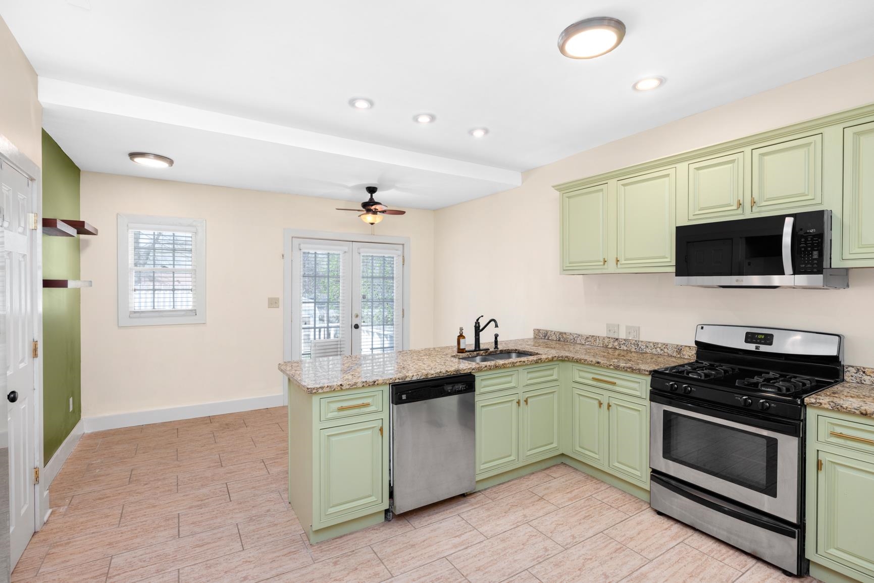331 Alexander Street Memphis, TN 38111 - Photo 13 of 25 Kitchen with green cabinets, stainless steel appliances, a peninsula, light stone countertops, and ceiling fan