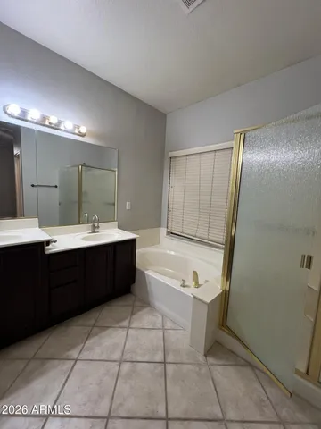 a bathroom with a tub a sink a mirror and a shower