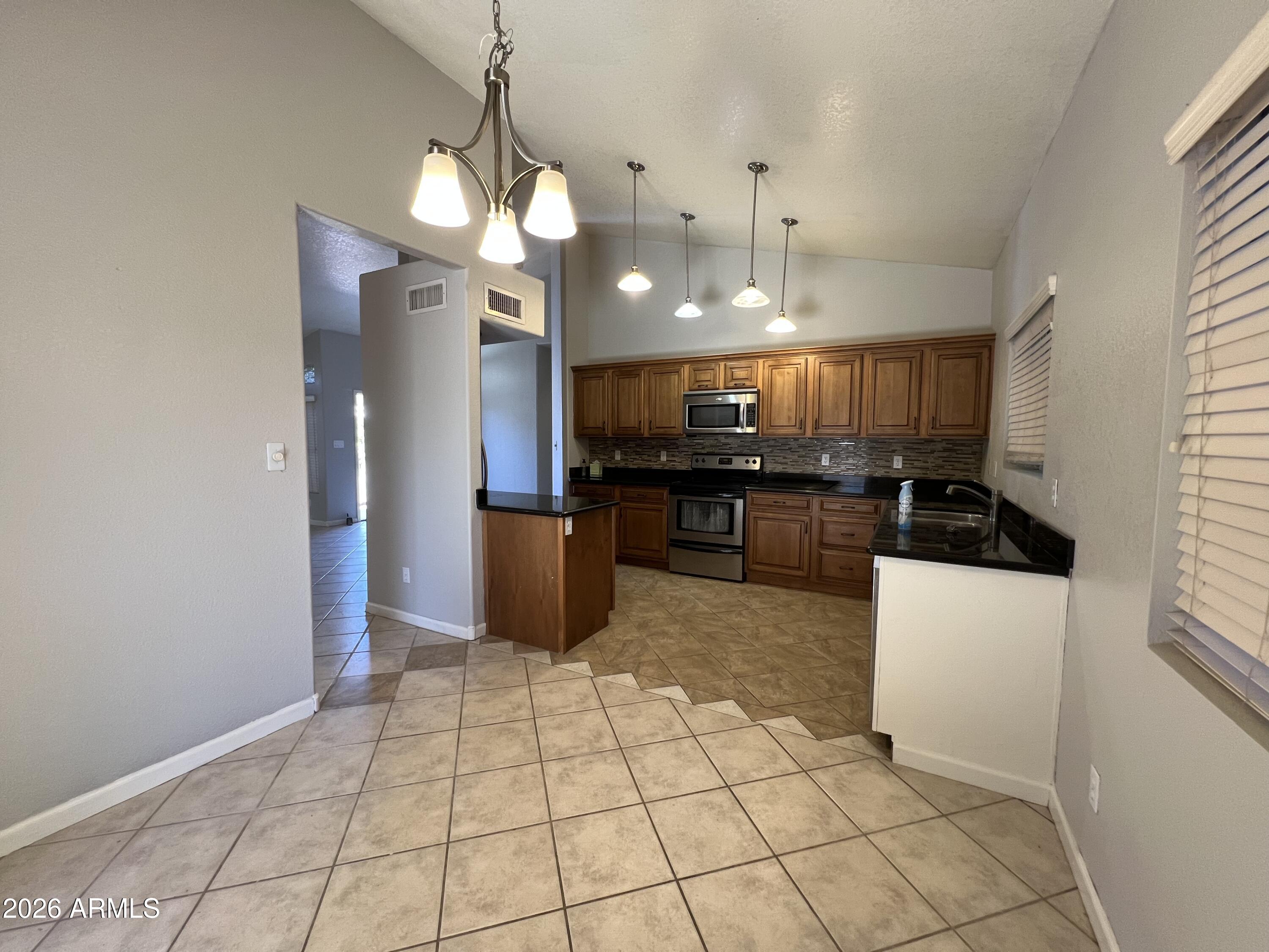 261 West Verano Place Gilbert, AZ 85233 - Photo 6 of 17 a kitchen with stainless steel appliances granite countertop a refrigerator a sink a stove and a microwave
