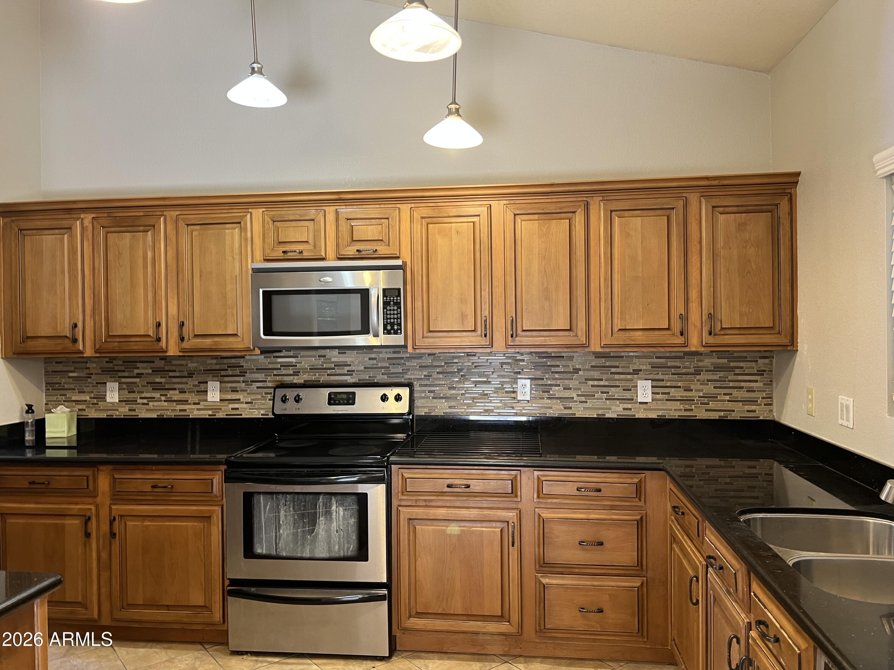 261 West Verano Place Gilbert, AZ 85233 - Photo 7 of 17 a kitchen with granite countertop a sink cabinets and stainless steel appliances