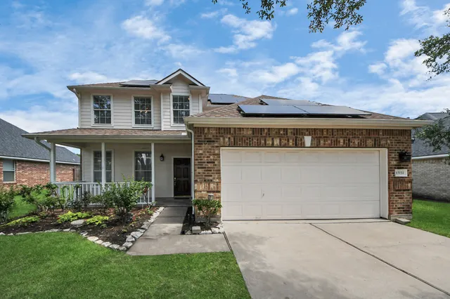 a view of a house with brick walls and a yard with plants