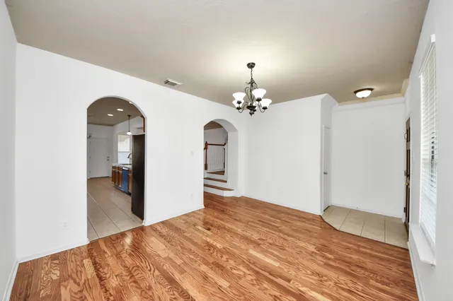 a view of empty room with fireplace and wooden floor