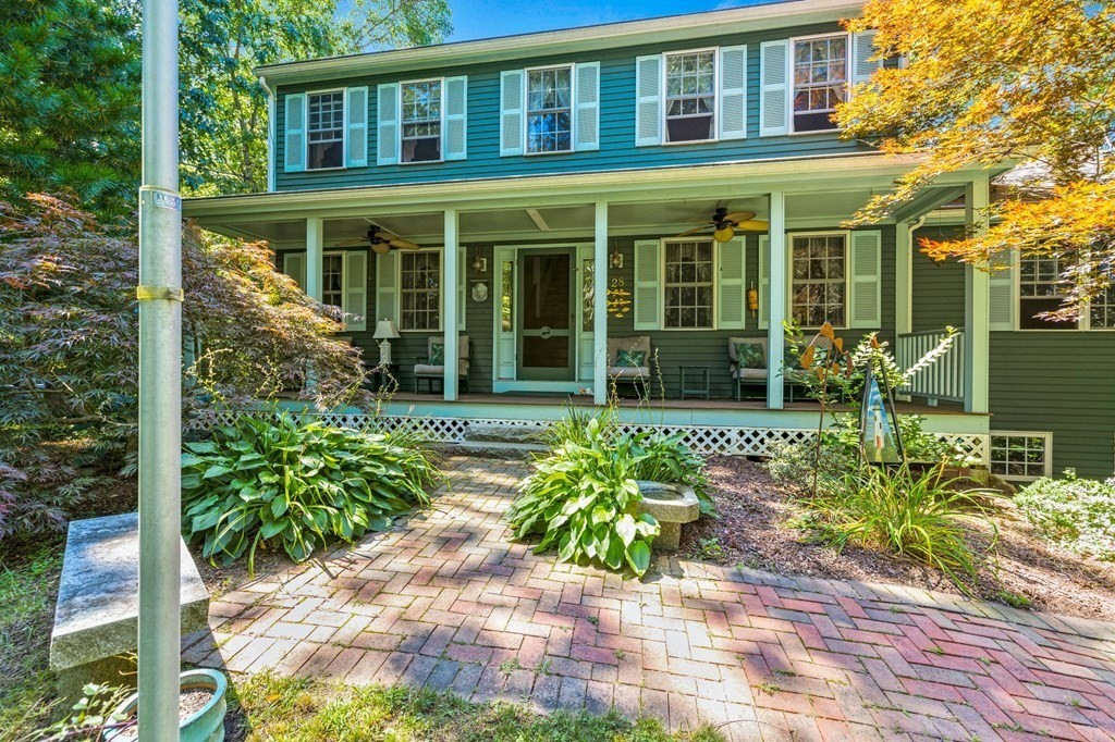 front view of a brick house with a large window and a yard