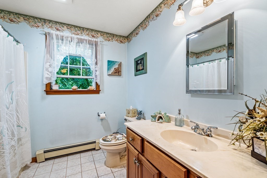 28 Crowell Road Bourne, MA 02562 - Photo 28 of 42 a bathroom with a sink a toilet and a mirror