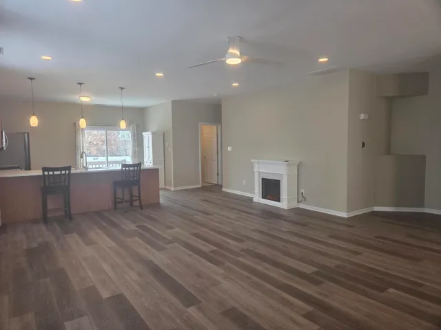 a kitchen with stainless steel appliances granite countertop a sink a stove and a wooden floors