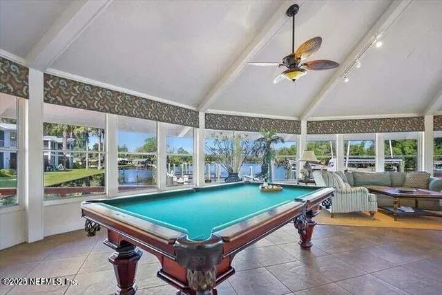 a room with pool table windows and a ceiling fan