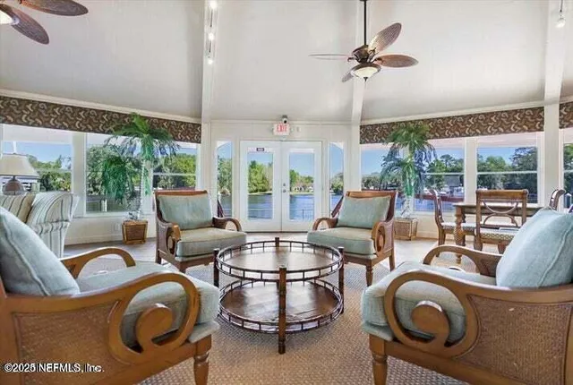 a living room with furniture a floor to ceiling window and a table