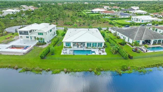 an aerial view of a house with a garden and lake view