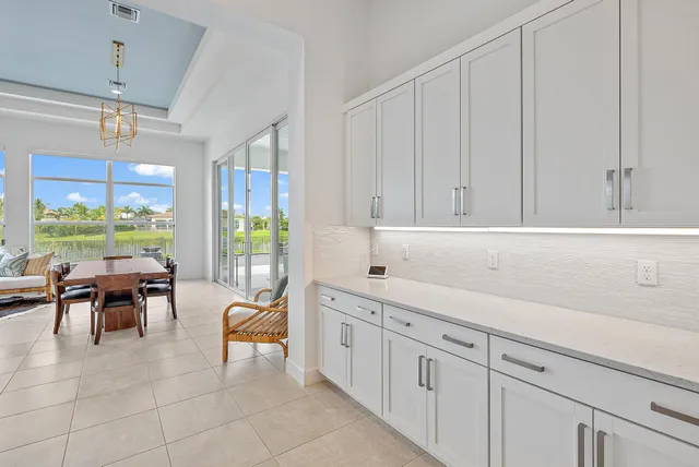 a living room with furniture a ceiling fan and a large window