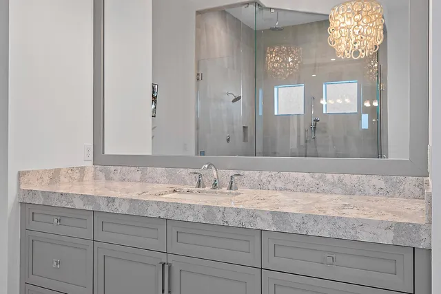 a bathroom with a granite countertop sink and a mirror