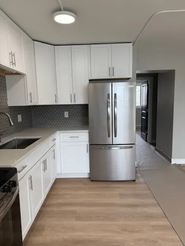 a kitchen with a refrigerator sink and cabinets